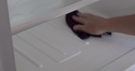 Close up of woman washing fridge shelf with wet rag at home. Cleaning day at the kitchen. Static camera