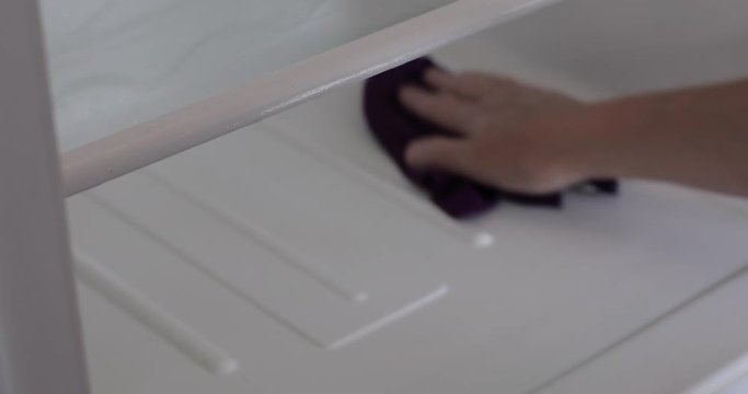 Close up of woman washing fridge shelf with wet rag at home. Cleaning day at the kitchen. Static camera