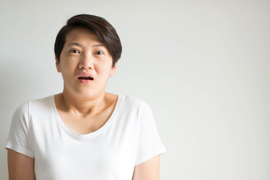 A woman portrait in an expression of stunned, frightened and panic on white background.