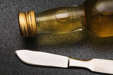 Scalpel and a bottle of whiskey on the table, close-up. The concept of alcohol abuse by surgeons
