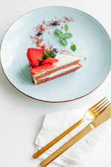 A beautiful piece of cake with berries with butter cream on a white background. Cake with red cakes.