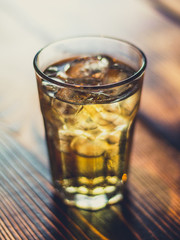Prickelnder Cocktail im Glas mit Eis auf Tisch aus Holz in Bar