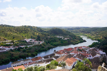 Naklejka na ściany i meble Small town of Mertola in Portugal seen from above, roofs of the houses and river. 