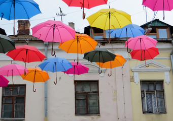 Fototapeta na wymiar colorful umbrellas on the background of the old house