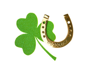 Golden horseshoe with phrase GOOD LUCK and clover on white background. St. Patrick's Day celebration