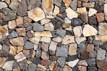 Texture of a yellow granite stone wall for background