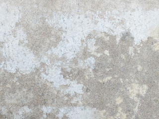 grey concrete floor with many traces of wear and tear due to foot traffic.