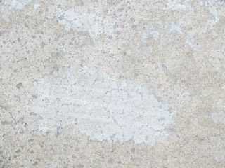 grey concrete floor with many traces of wear and tear due to foot traffic.