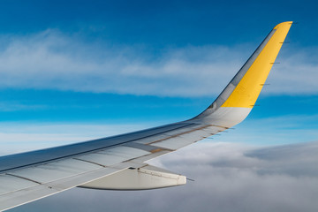 ala de un avión airbus a320 sobrevolando montañas españolas, de fondo el cielo con nubes en un...