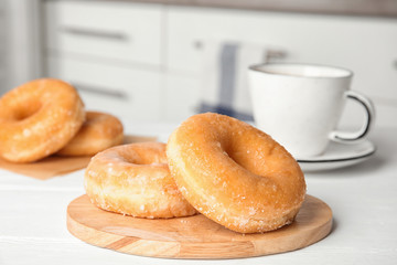 Sweet delicious donuts on white wooden table