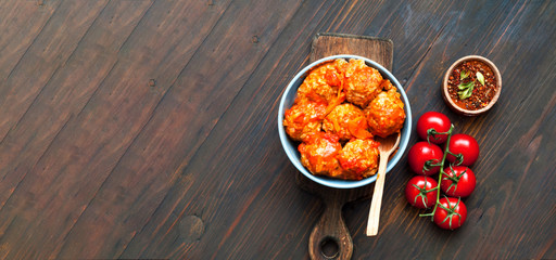 Meatballs in blue bowl on wooden background. Close-up