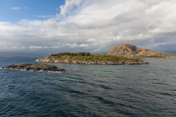 Fototapeta premium Norwegian fjord and mountains surrounded by clouds, ideal fjord reflection in clear water. selective focus.