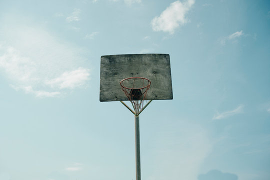 Old basketball backboard under blue sky