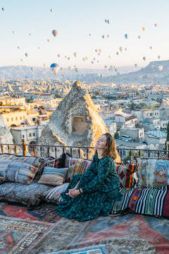 Woman at sunrise with hot air balloons raising up in Cappadocia Turkey