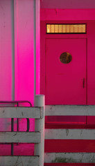 Close view of a red entrance door to a lounge under purple light