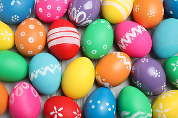 Fototapeta na wymiar Many bright Easter eggs on wooden background, top view