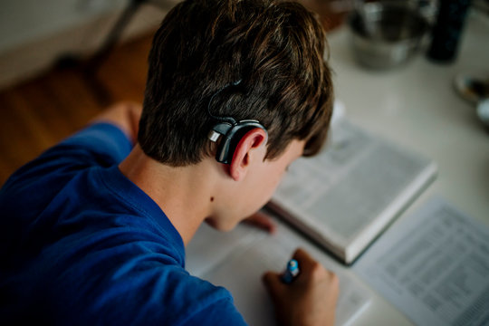 Studious teenager with cochlear implant doing homework