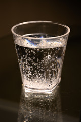 Plastic transparent glass with sparkling water with bubbles