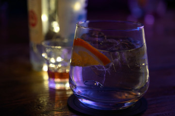 Glass of gin with tonic water, orange and ice