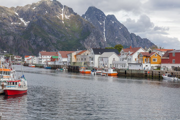 Fototapeta na wymiar Scenic view of the waterfront harbor in Henningsvaer in summer. Henningsvaer is a fishing village and tourist town located on Austvagoya in the Lofoten Islands. Norway