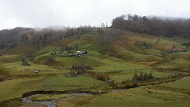 Autumn landscape with traditional houses in Fundatura Ponorului, also known as "The palm of God", Sureanu Mountains, Romania