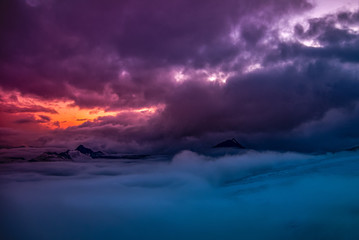 Panorama of high mountains and clouds, colorful sunset in the background. Mount Elbrus, Caucasus, Russia.