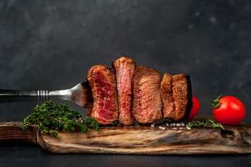 Foto op Plexiglas four steaks on  fork on a cutting board on a stone background.Four types of meat frying Rare, Medium, Medium Well, Well Done © александр таланцев