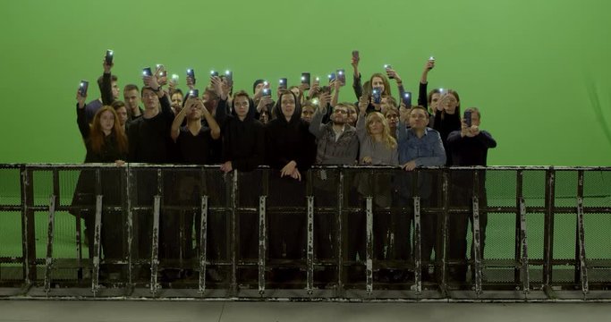 GREEN SCREEN CHROMA KEY Model released, Front view of huge crowd dancing and cheering at a concert or a show behind control barrier. Shot on RED Helium 8K Prores 4444