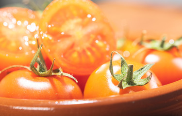 tomates cherry en rama recien recogidos en mader y vasija de barro
