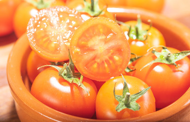 tomates cherry en rama recien recogidos en mader y vasija de barro