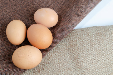 four brown chicken eggs on a dark background close-up