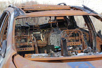 burnt car on the forest, rusty metal