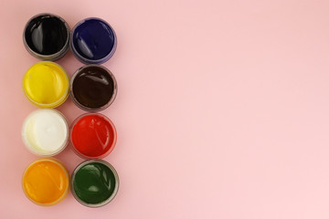 Gouache cans on a pink background with space for text