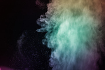 Colorful smoke flowing in a dark background. Abstract backdrop with fume and colorful light effect. Mystic dream. Colorful dust explode. Paint Holi. Halftone smoke effect. Vibrant abstract background.