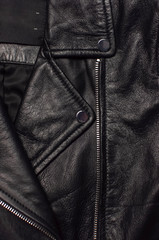 Close up details Black women's leather jacket top view. Fashionable modern trendy women's clothing. Vintage biker jacket. Black genuine leather texture
