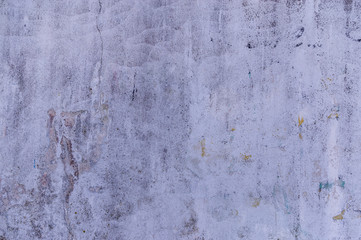 Verputzte Wand mit mehreren Anstrichen übermalt in verschiedenen Farben die unterschiedlich stark abgeblättert sind durch Verwitterung und Abrieb dadurch entstanden unterschiedliche abstrakte Muster