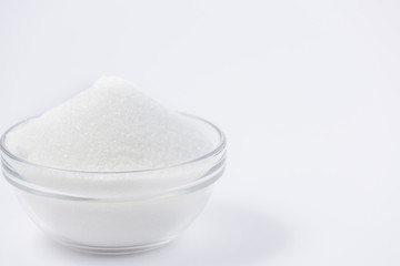 Brown sugar in a round glass cup on a white background, healthy sugar. Used for cooking or desserts.