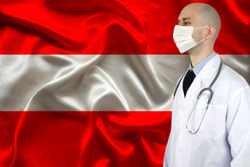 male doctor with a stethoscope against the background of the silk national flag of Austria, concept of national medical care, health, insurance, tourism