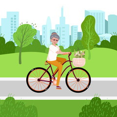 Senior woman on the bicycle in the park. Elderly activity. Old Lady goes to sport, cycles. Elegant person is sitting on the bicycle with flowers. Healthy urban activity lifestyle for retiree.