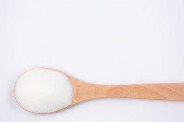 Brown sugar in a wooden spoon on a white background, healthy sugar. Used for cooking or desserts.