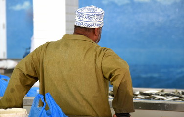 Traditionell bekleideter Omani auf dem Fischmarkt von Muttrah