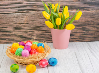 Beautiful group Easter eggs in the spring of easter day, red eggs, blue, purple and yellow in Wooden basket on the table background wood.
