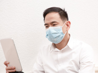 The image of a young Asian man wearing a mask to prevent germs, toxic fumes, and dust. Prevention of bacterial infection in the air around in the white background.
