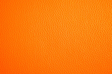 Obraz premium Leather texture close up. Orange fashionable background, top view. Stylish wallpaper with rough surface of coral color.