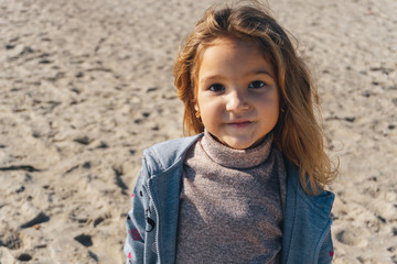 Portrait of a little girl on the sea sandy shore