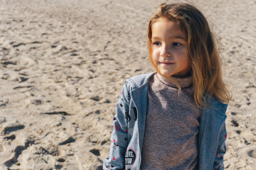 Portrait of a little girl on the sea sandy shore
