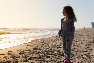 Little girl on the sandy shore of the ocean