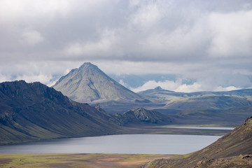 Fototapeta premium View mountain valley with green hills, river stream and lake. Laugavegur hiking trail, Iceland