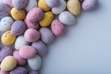 Colorful mini Easter eggs on a plain back ground with copy space