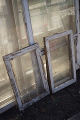 old dirty windows with white wooden frames removed from the openings during the repair